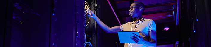 Man inspecting cables in a server rack.